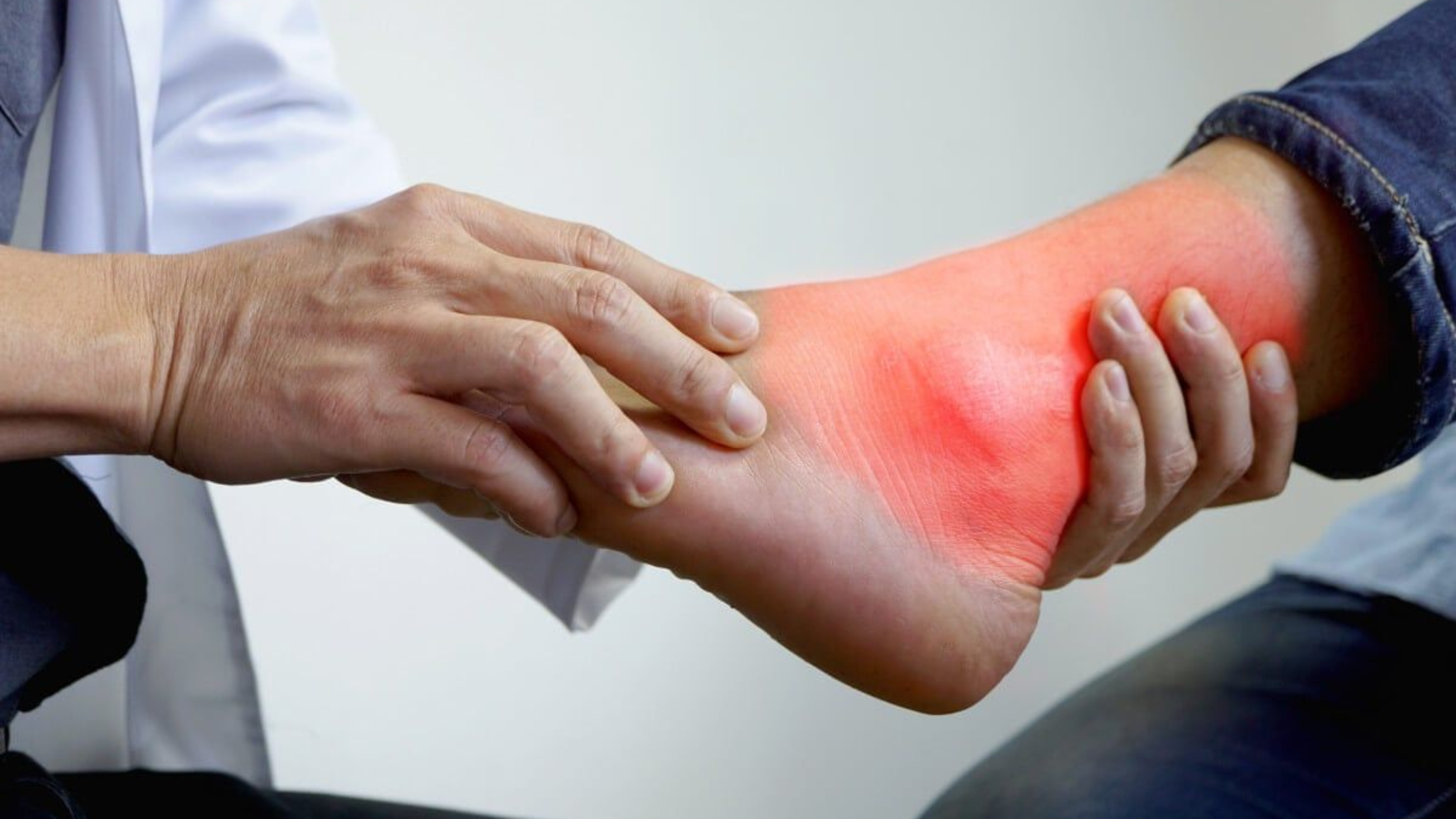 Doctor examining a patient with arthritis in the foot and ankle during a medical consultation.